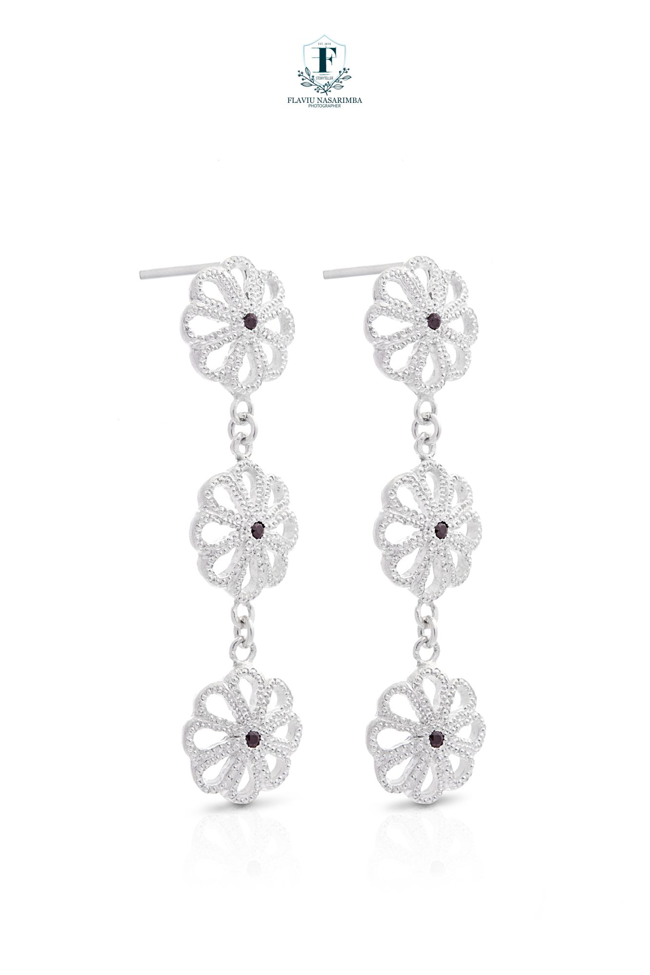 Triple flower drop earrings in silver with red crystal centers on white background.