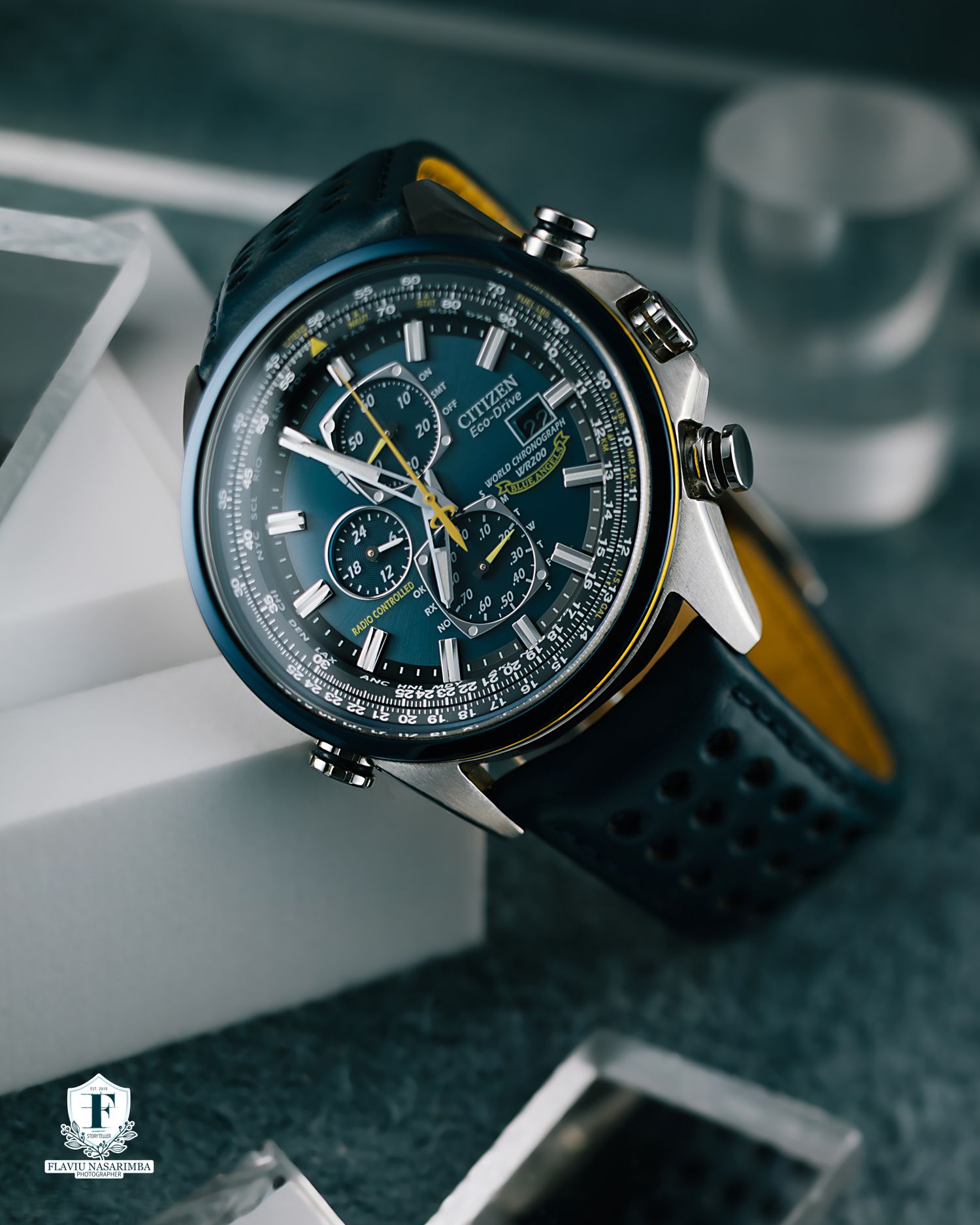 Citizen chronograph pilot watch with blue dial and tachymeter bezel on navy leather strap.