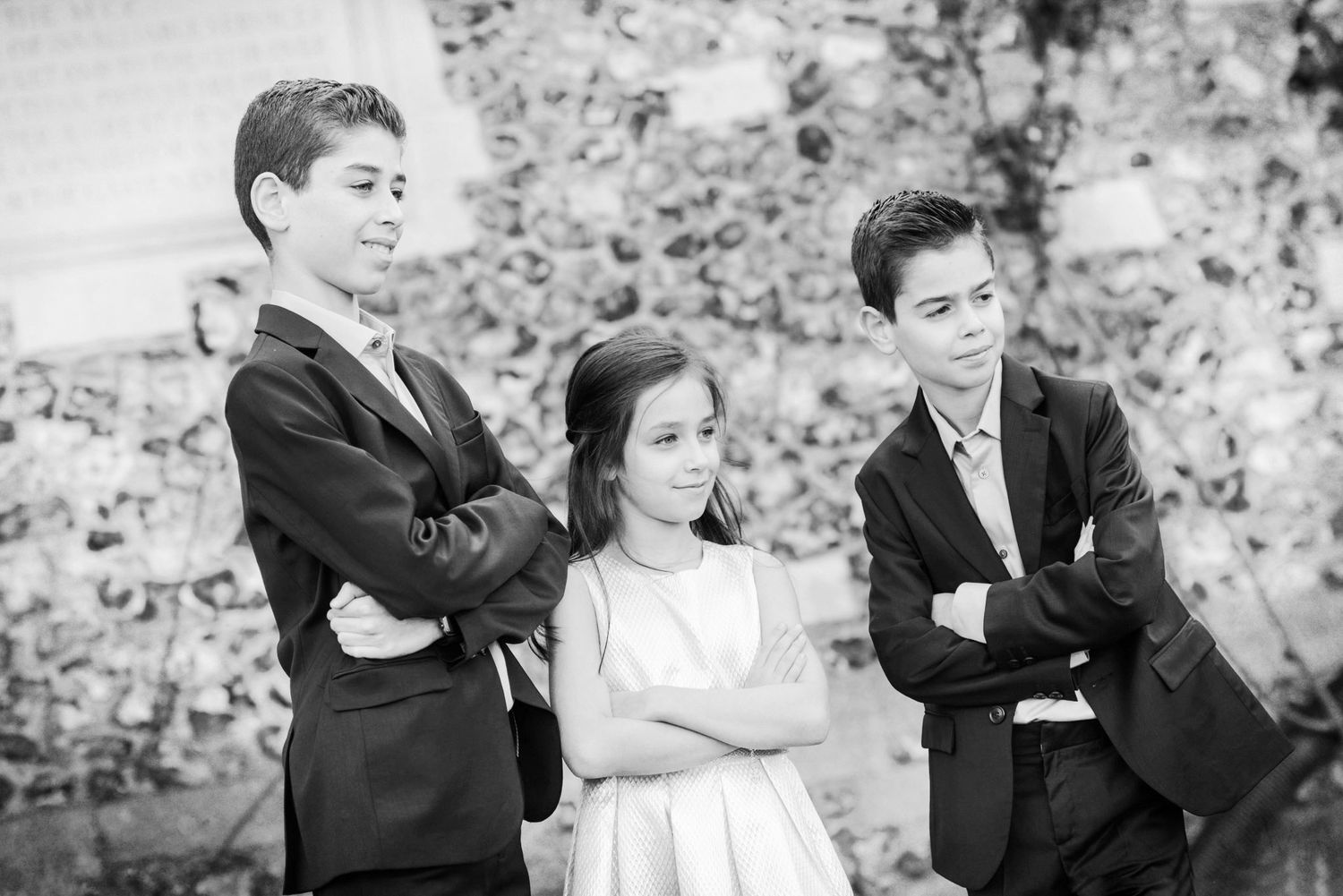 A series of black and white wedding photos showing candid moments between a couple in formal attire.