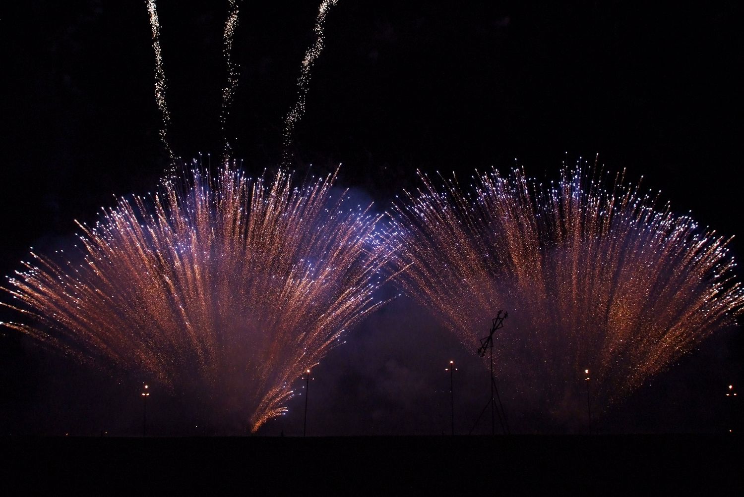 White fireworks display spreading across dark night sky in panoramic view.