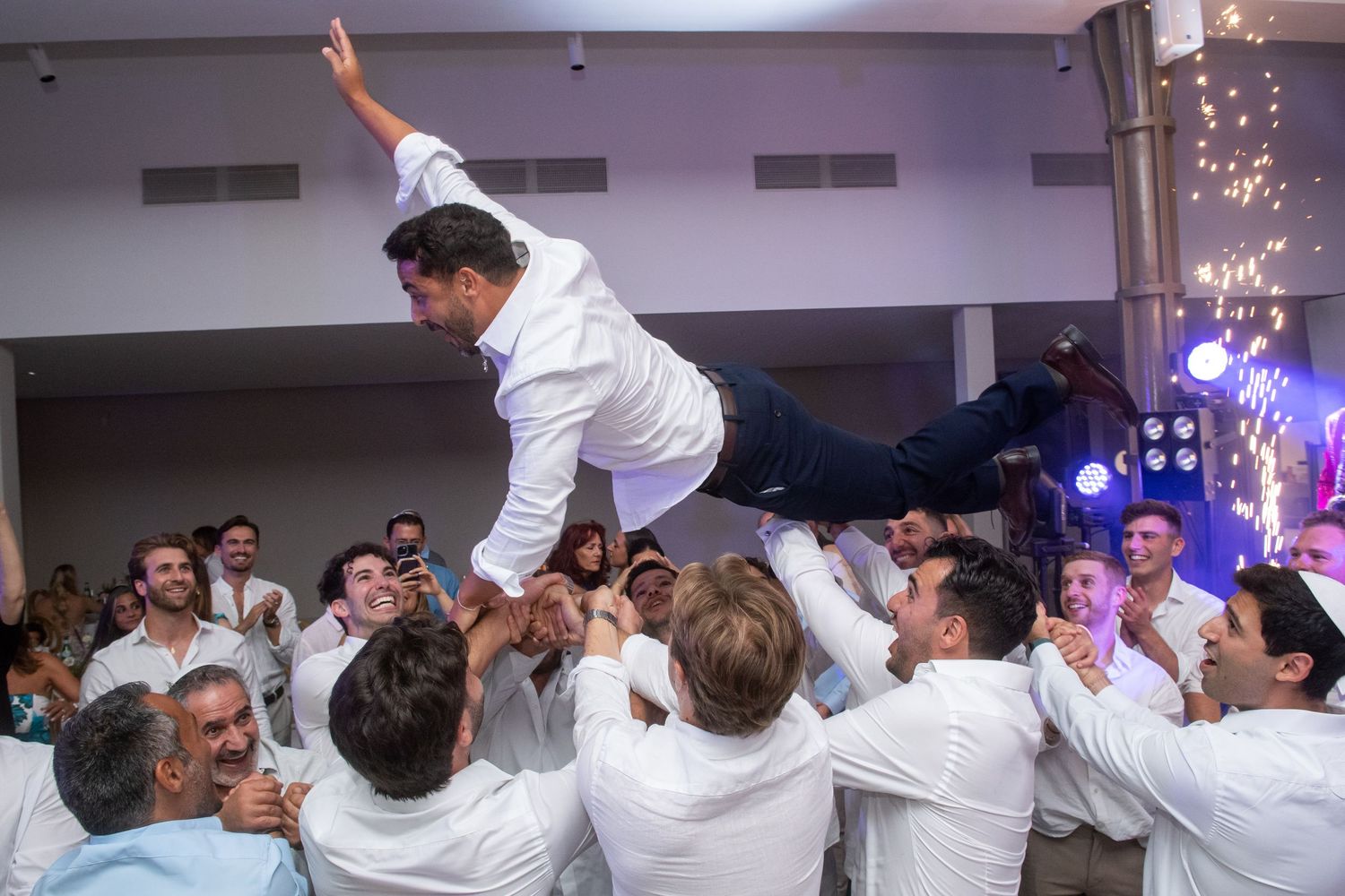 A sequence of dance party photos showing people celebrating and dancing in a white-themed event space with decorative lighting.