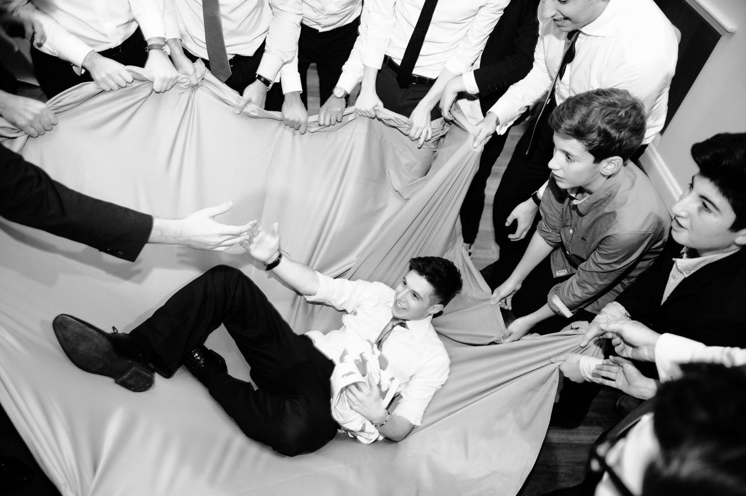 Black and white photos showing guests dancing and celebrating at a lively wedding reception.