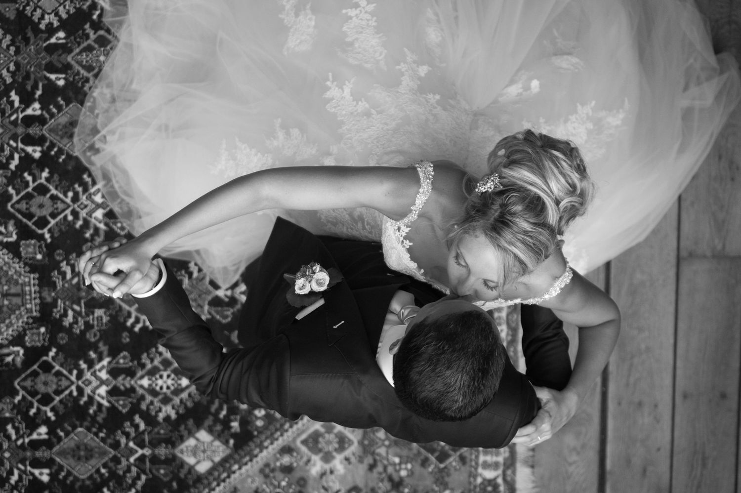 Aerial black and white photo of bride and groom sharing first dance at wedding reception.