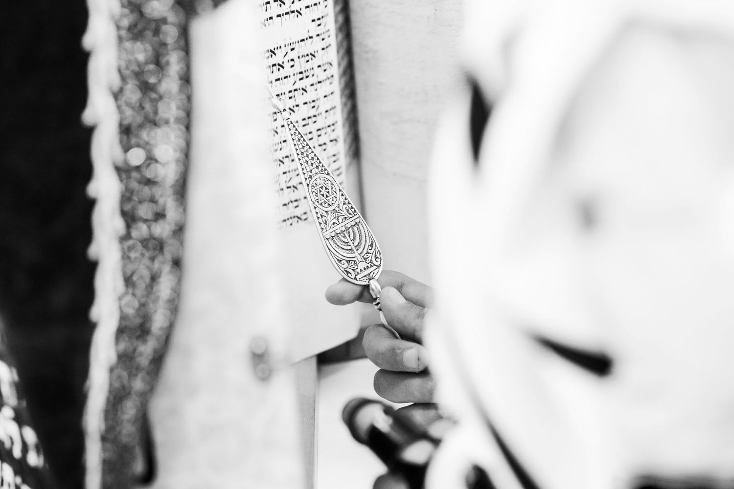 Black and white close-up photograph of hands exchanging wedding rings during a ceremony.