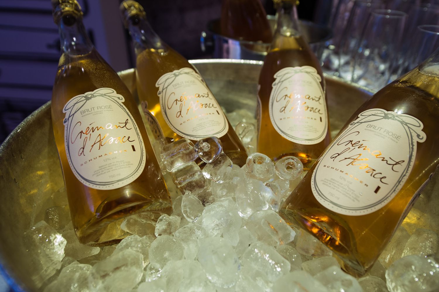 Chilled bottles of champagne on ice in an elegant gold serving bowl.
