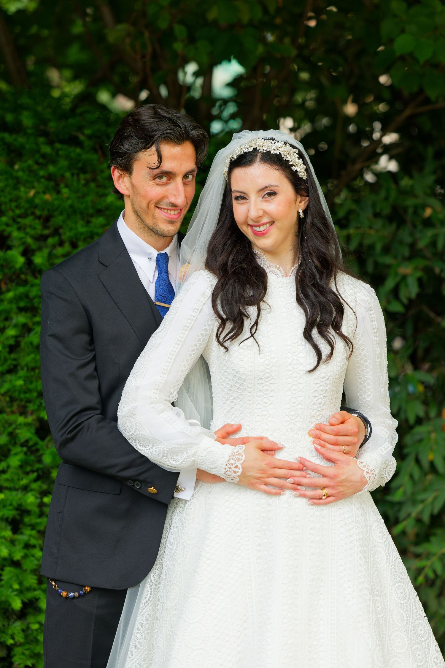 A romantic wedding photo series showing a couple embracing outdoors with lush greenery in the background.