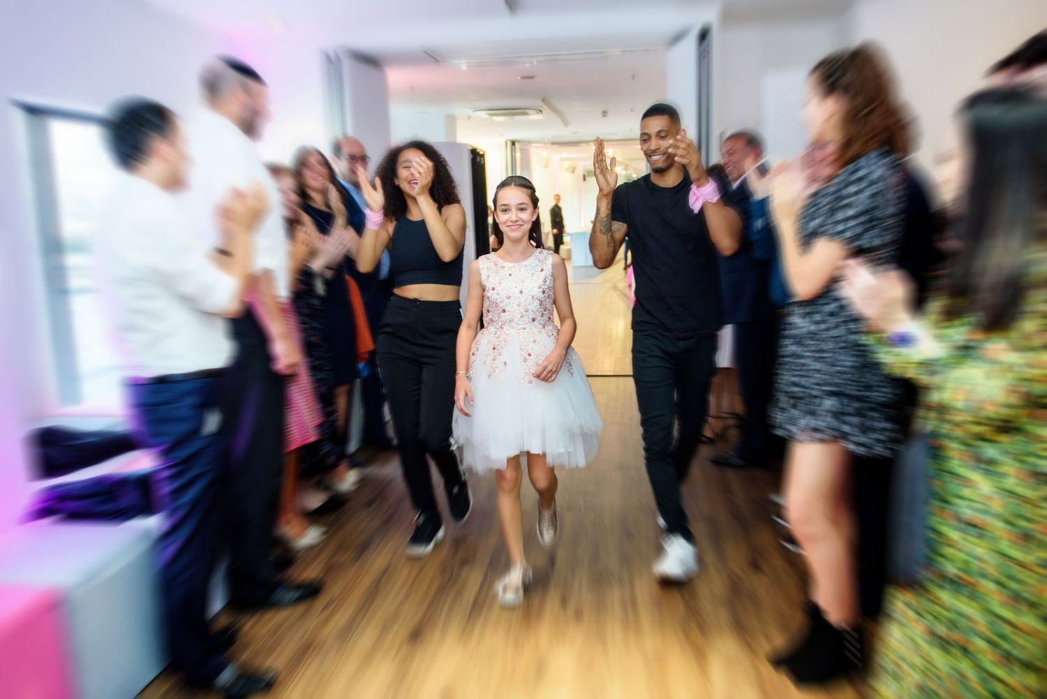 Blurred motion of wedding guests dancing and celebrating on dance floor.