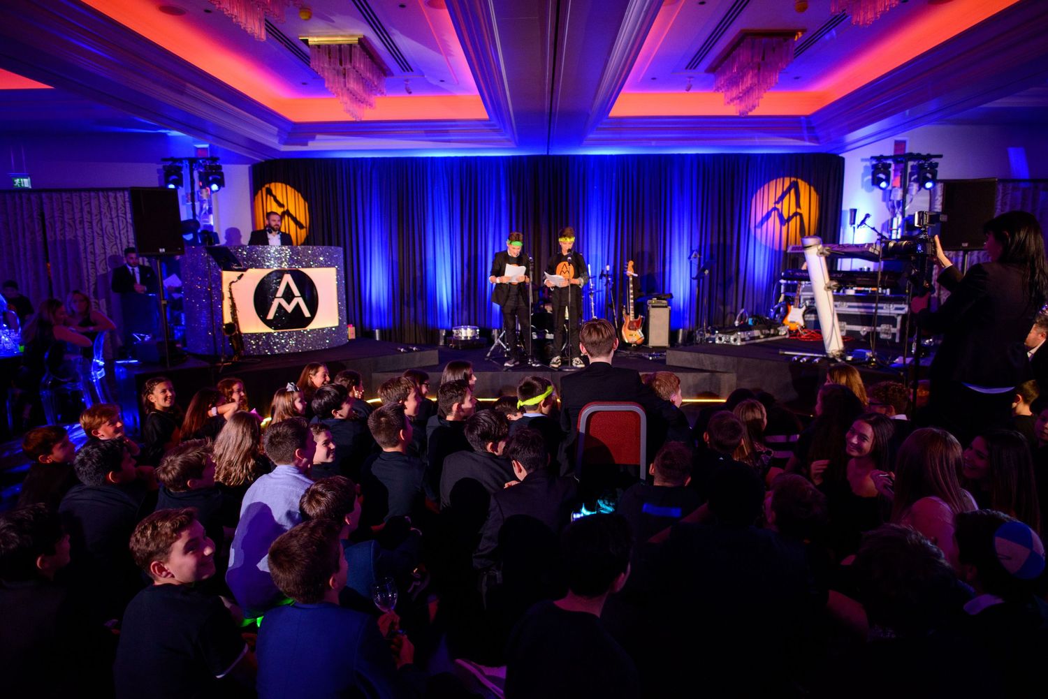 A dark event venue illuminated with vibrant blue and red lighting during a conference or performance.