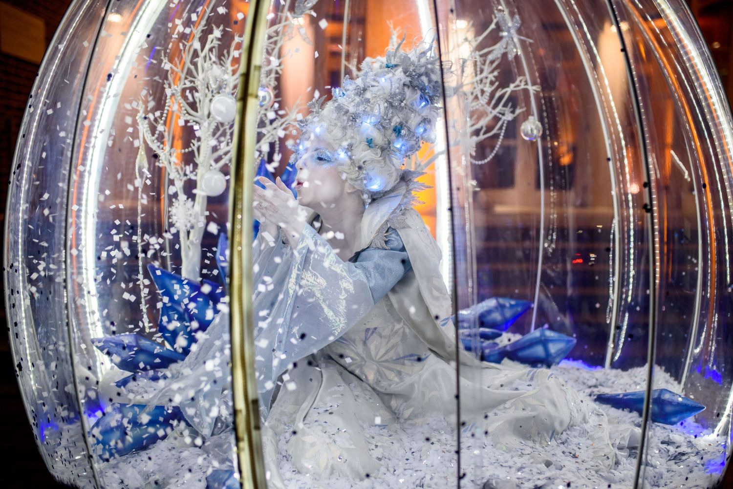 Decorative transparent domes with blue lighting create an ethereal atmosphere at an indoor event.