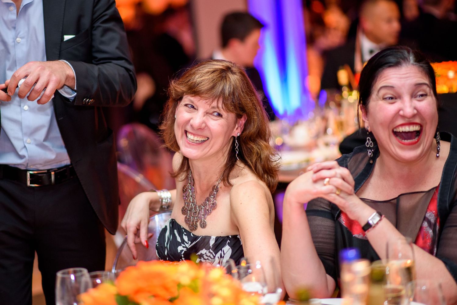 Wedding guests sharing laughter and conversation at decorated reception tables.