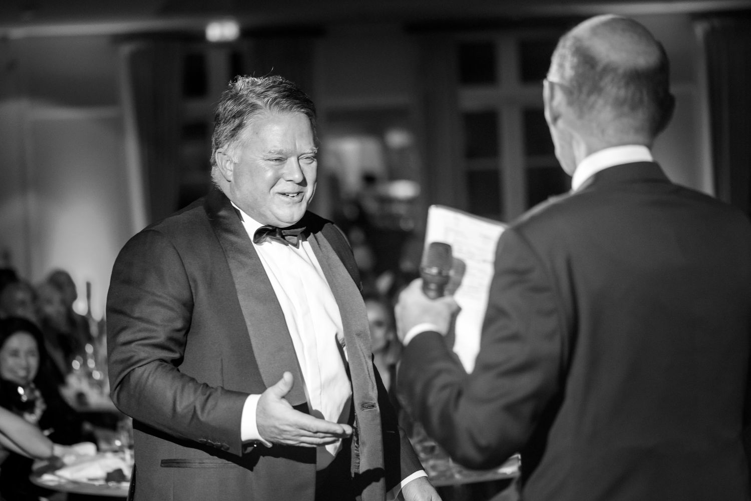 Black and white photos of formal event interactions and conversations.