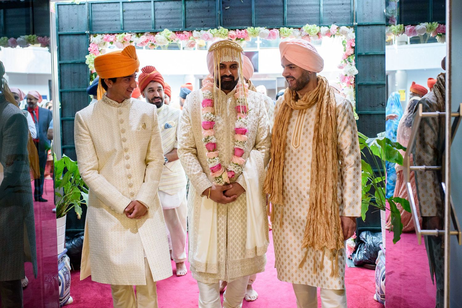 Traditional Indian wedding guests in formal ethnic attire stand together during an outdoor celebration ceremony.