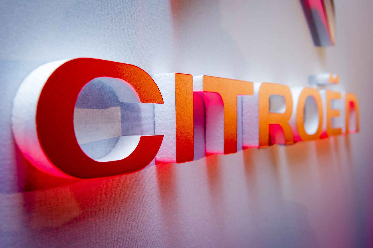 Illuminated Citroen logo signage with red and orange gradient lighting.