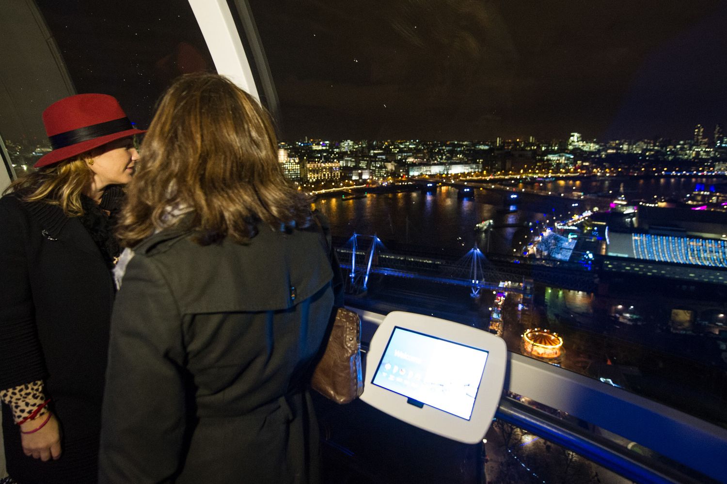 Event attendees view a nighttime cityscape from an elevated venue with blue lighting.