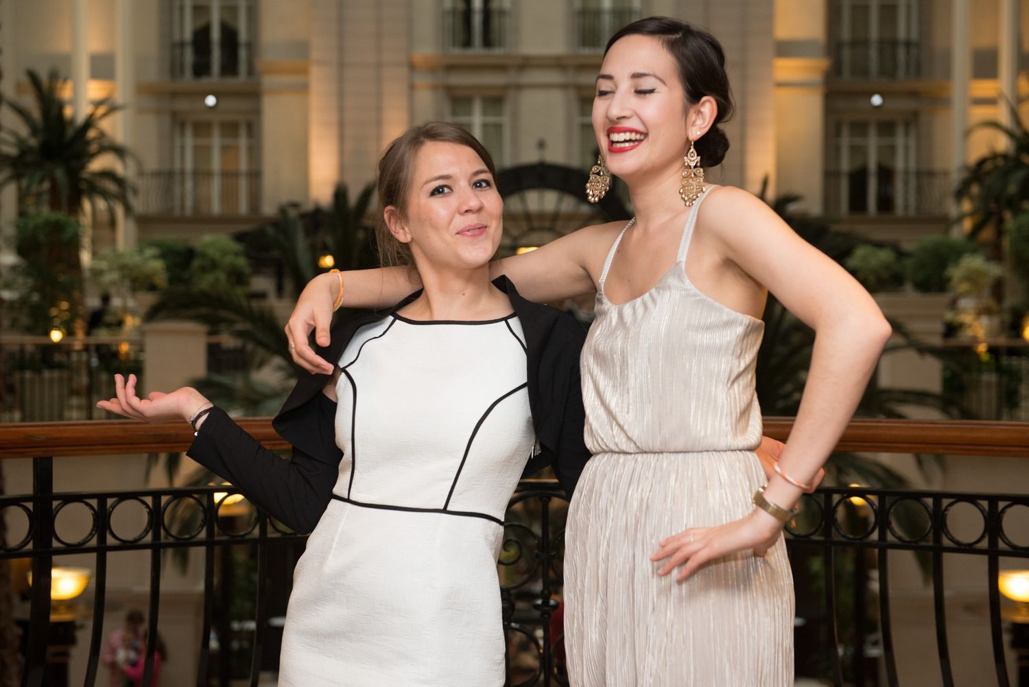 Two people in formal attire dancing and laughing at an evening event.