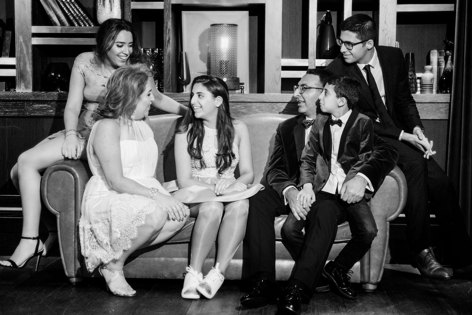 A collection of black and white wedding photos showing candid moments of couples and guests at a reception.