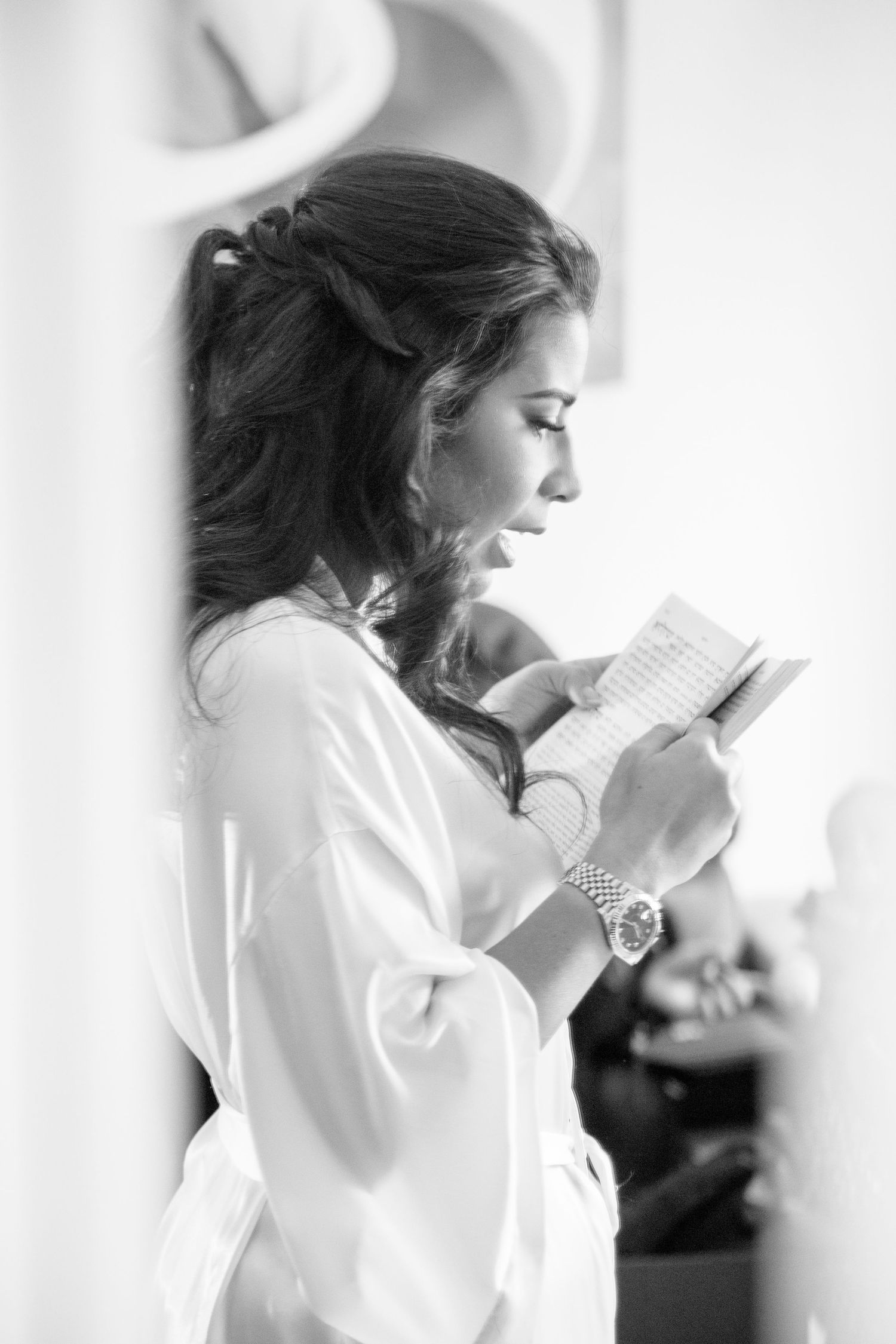 A series of black and white photos showing someone in a white robe reading a letter with emotional expressions.