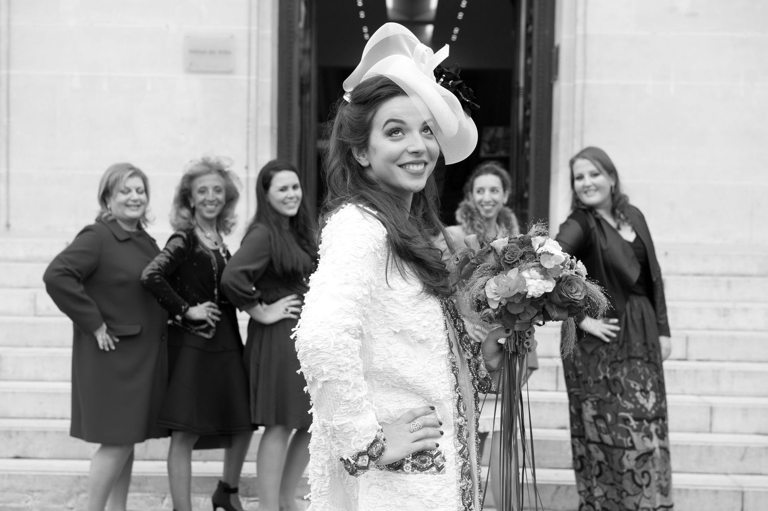 A group of people in formal attire pose together in a black and white photograph.