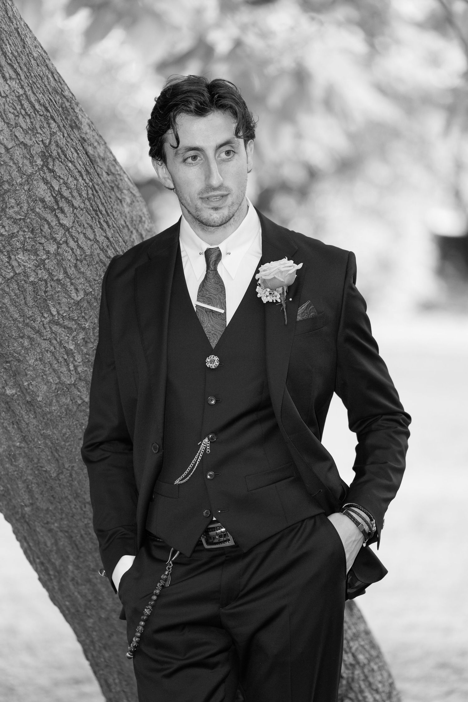 A black and white photo series showing a person in a vintage suit posing against a textured background.