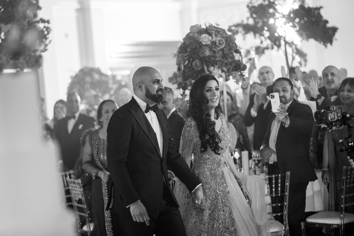 Wedding guests dance and celebrate on a dimly lit dance floor during an evening reception.
