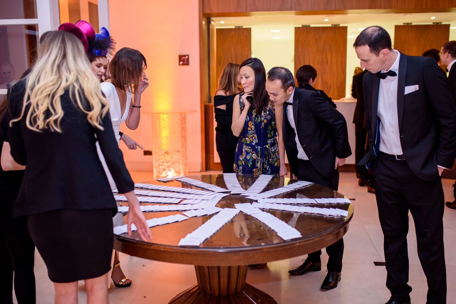 Corporate event setup with white tablecloths and attendees reviewing documents.