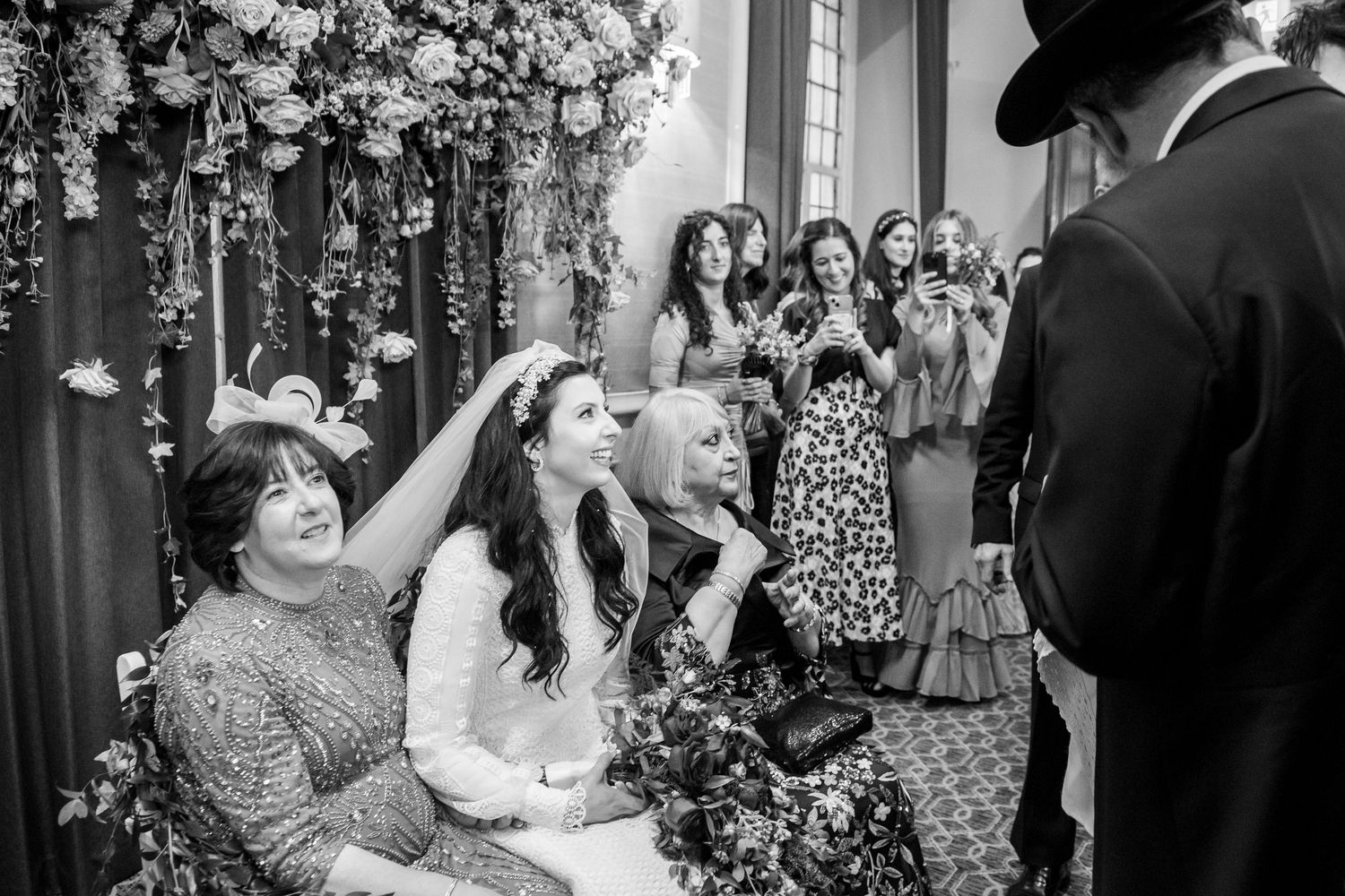 Wedding guests dance and celebrate on a crowded dance floor during an indoor reception celebration.