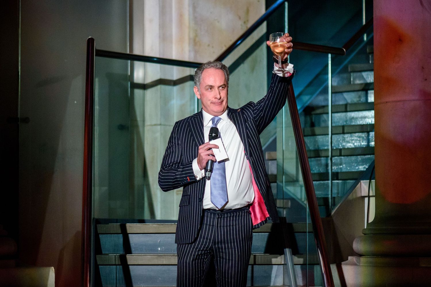 Professional speaker presenting on stage at formal business event.