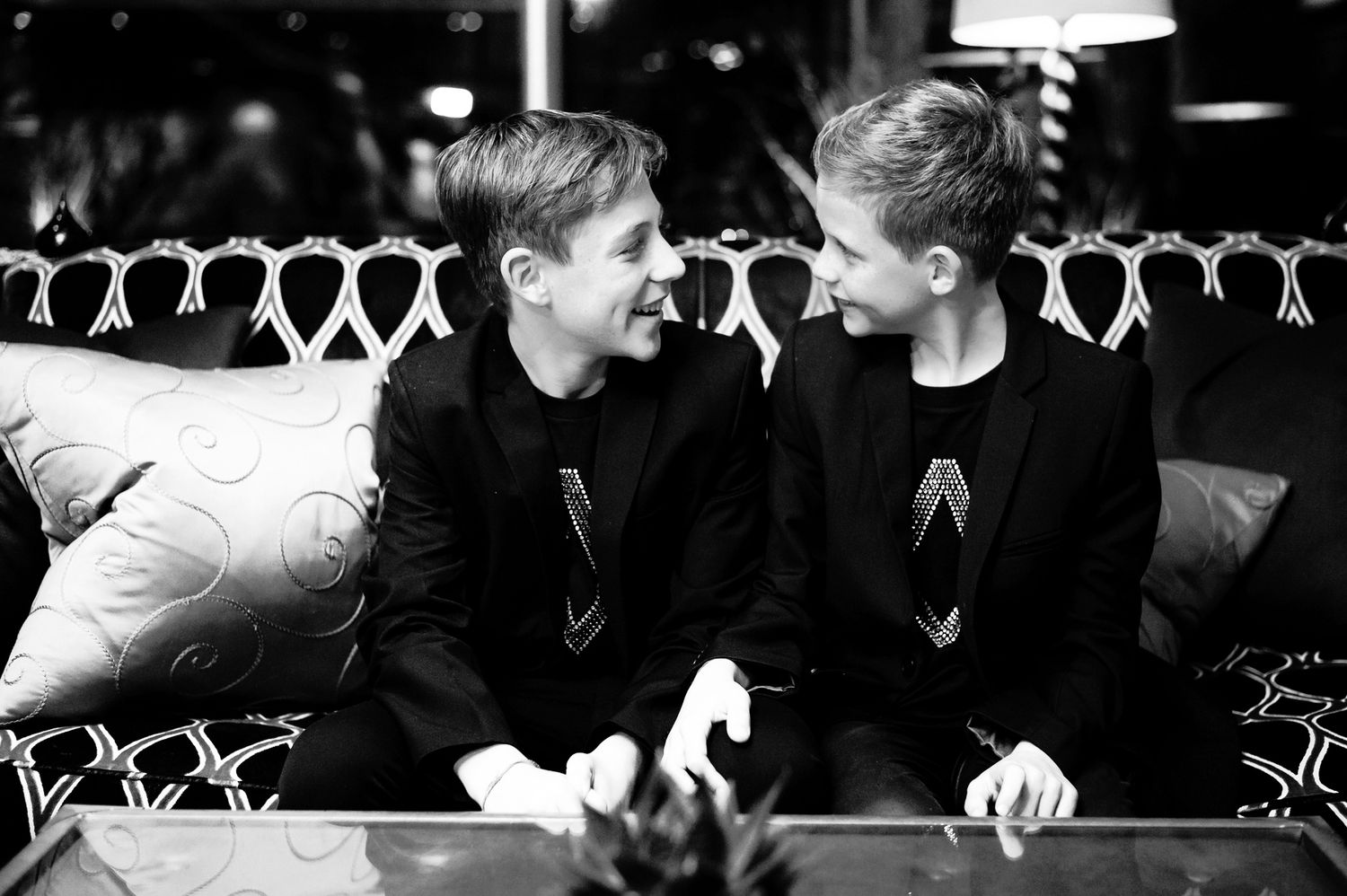 Two people share an intimate moment in black and white as paper heart decorations hang above them.