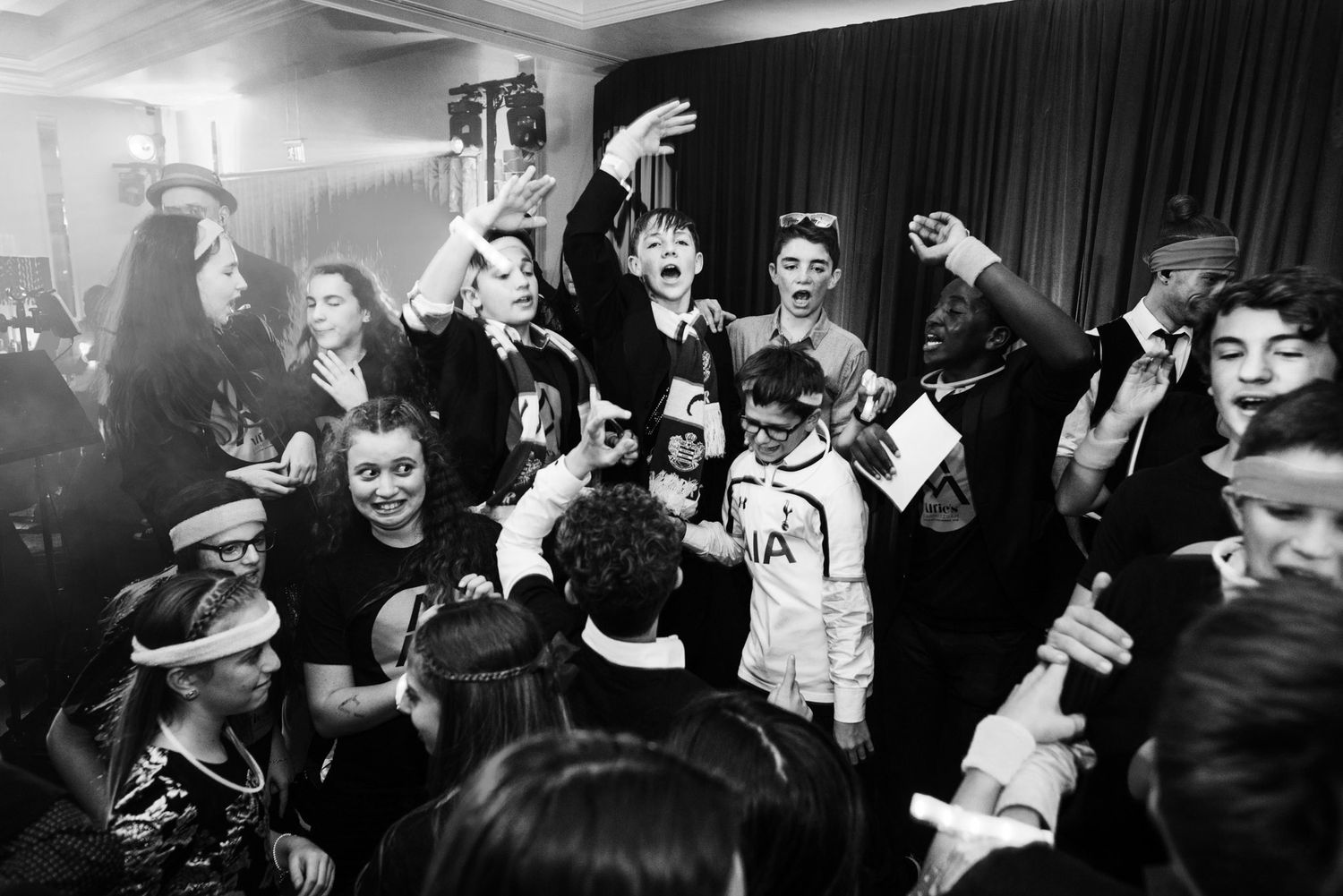 A lively black and white crowd shot at a music venue with people dancing and enjoying themselves in a dark space.