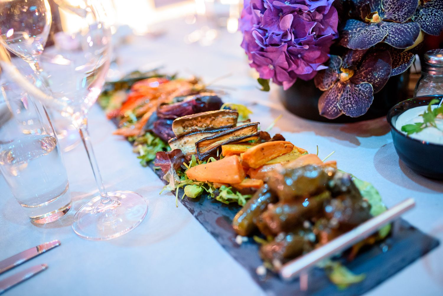 Elegant plated dishes and appetizers served at an upscale restaurant with artful presentation and garnishes.
