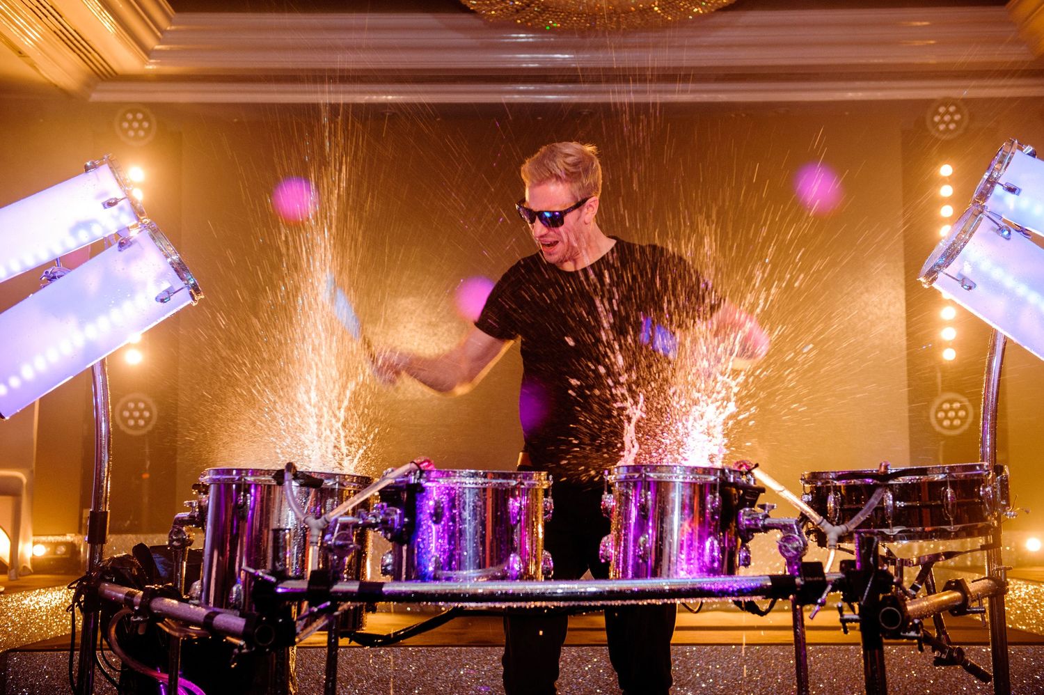 Elegant ballroom venue with ornate chandeliers and warm lighting during an evening celebration.