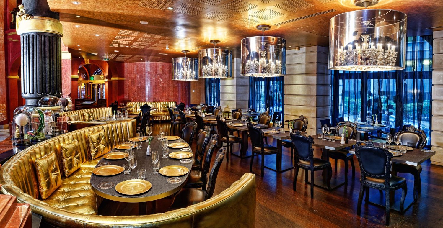 Luxurious restaurant interior with curved booths and warm wood paneling.