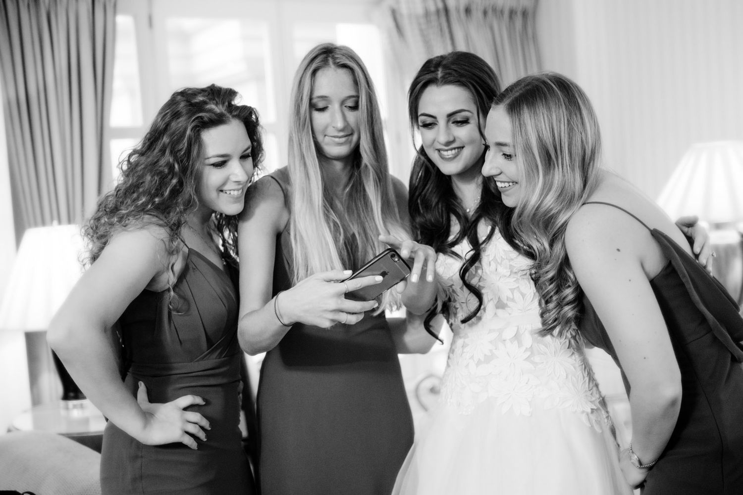 Candid black and white photos of bridesmaids sharing joyful moments together.