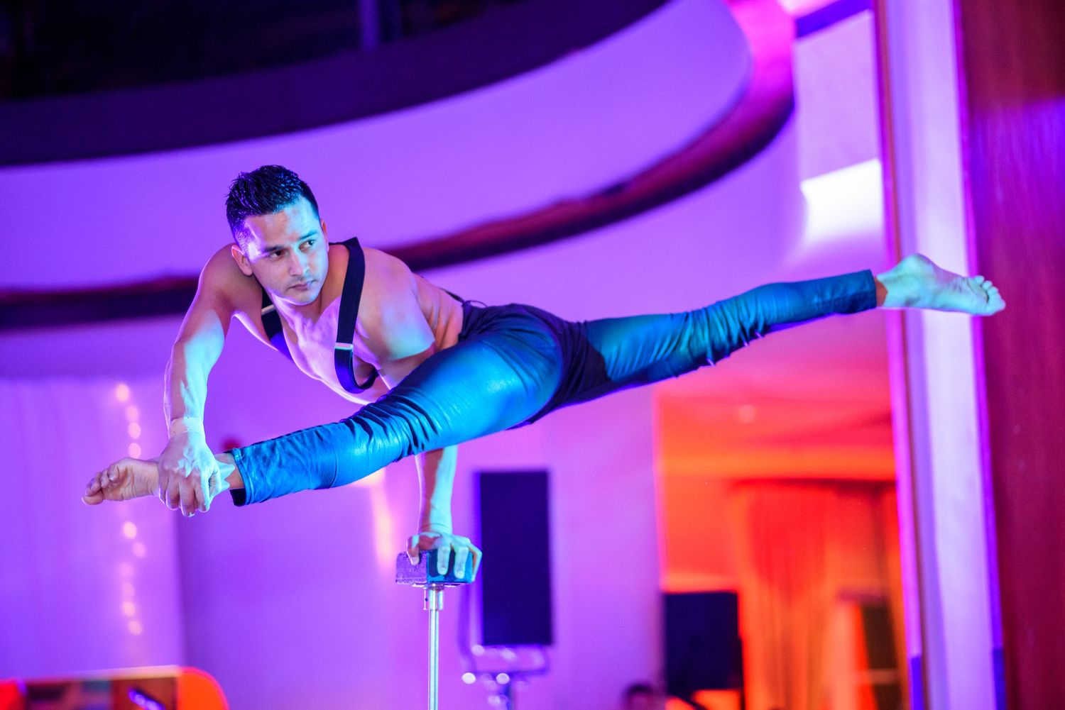 Dynamic dance performance with dramatic purple and blue lighting effects on stage.