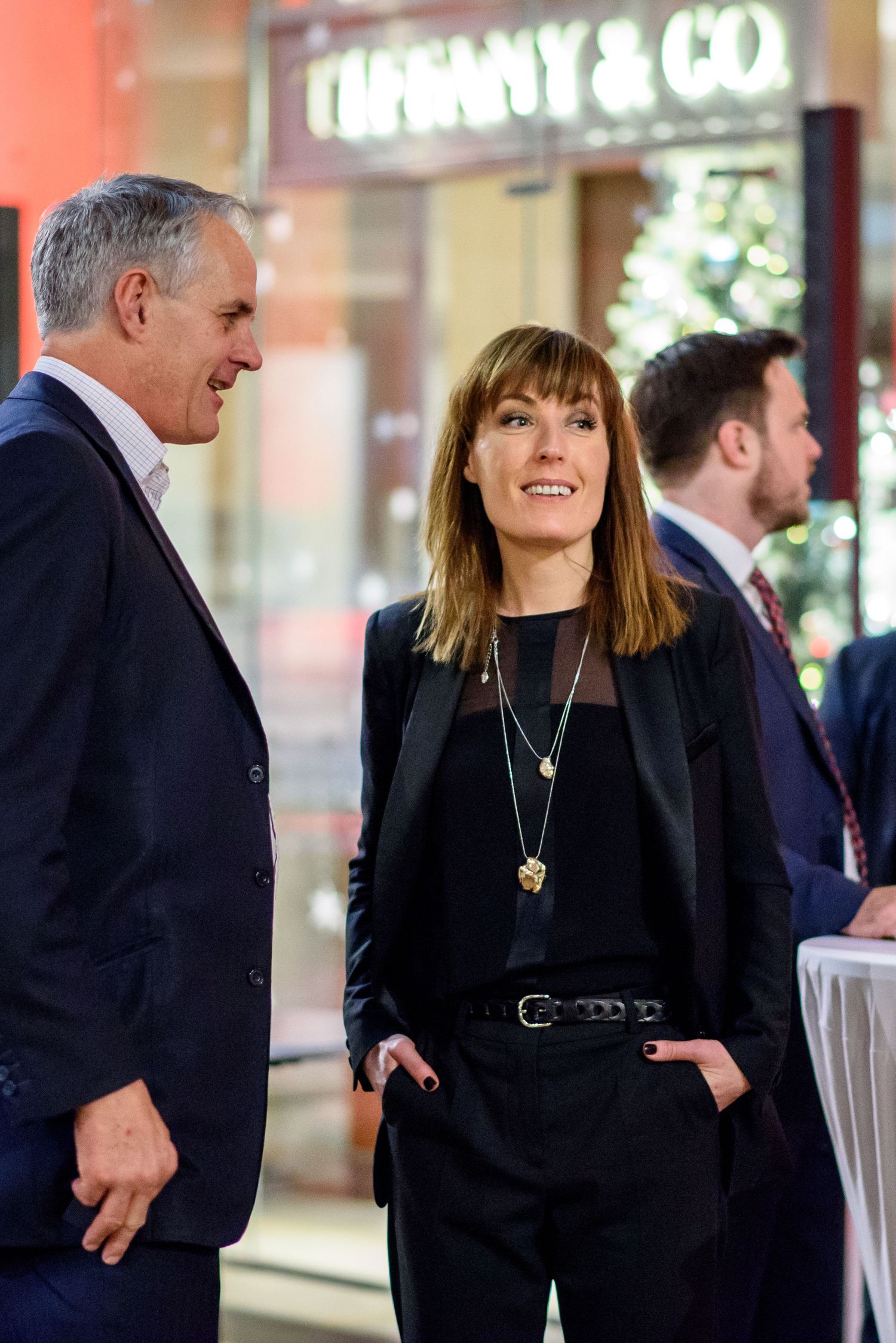 Professional networking event with attendees in formal business attire.