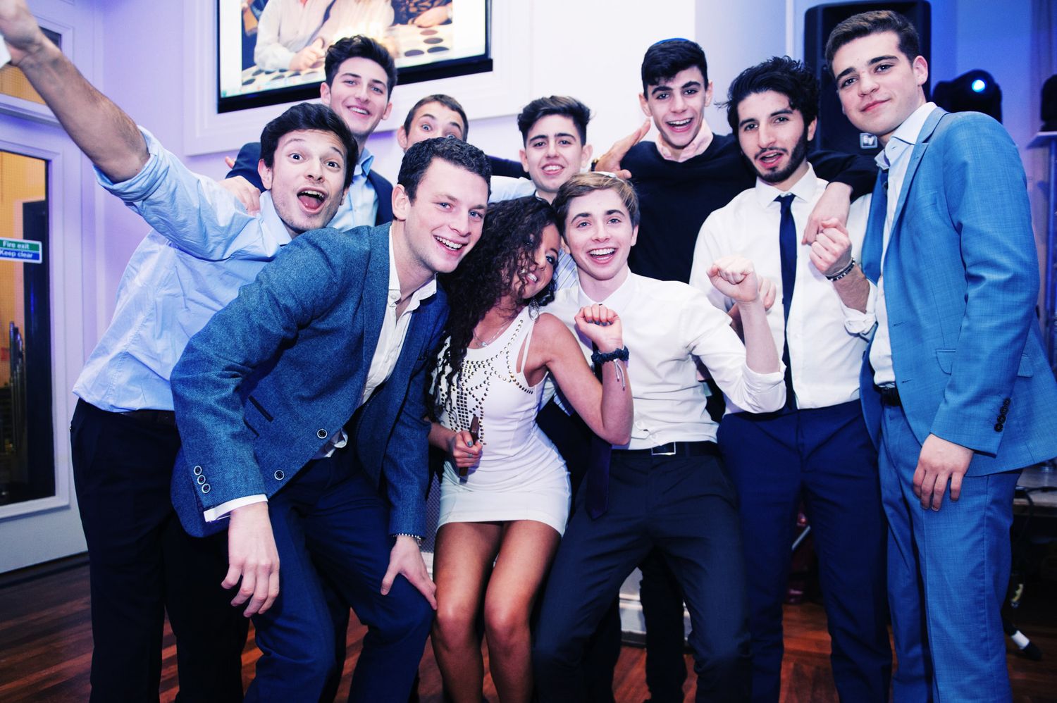 Wedding party poses together in a fun collage of candid celebration photos with blue lighting.