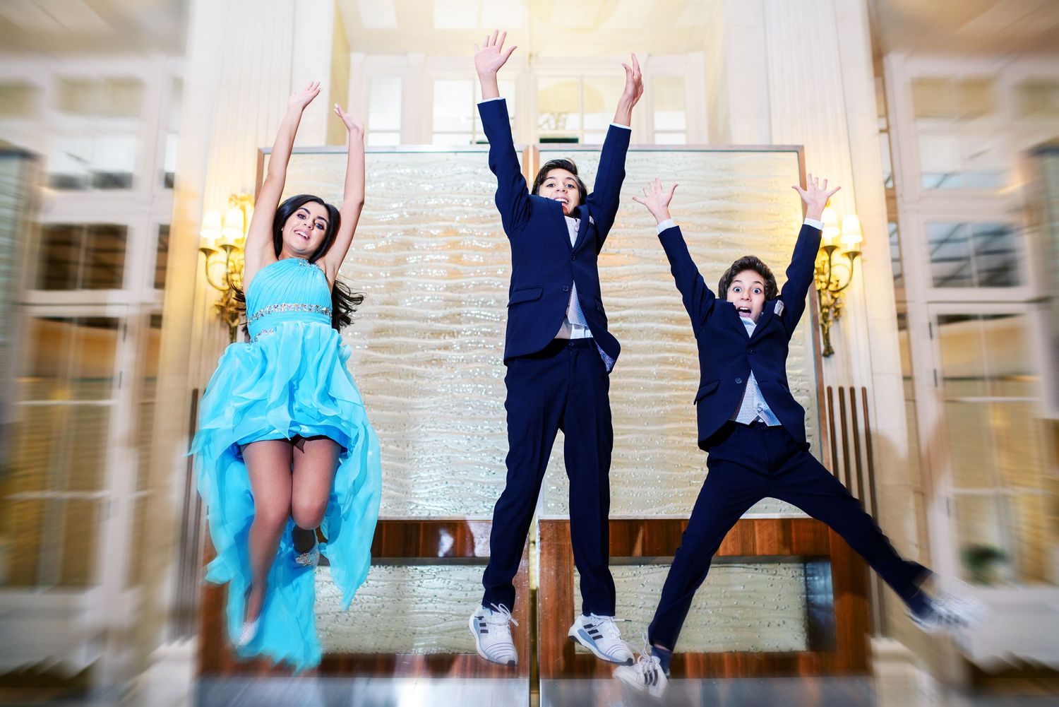 A sequence of wedding photos showing a couple jumping and posing playfully in an elegant indoor venue.