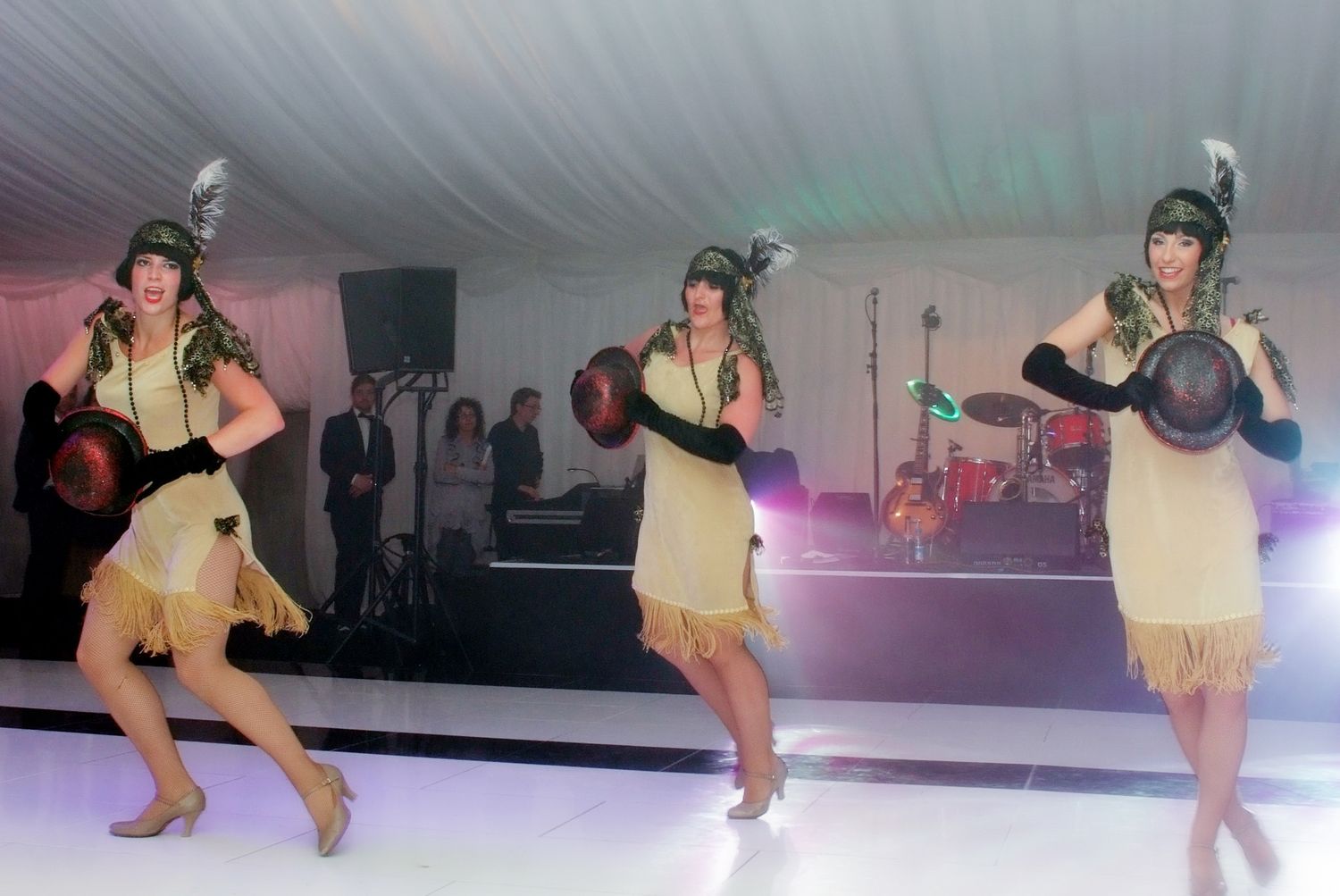 Ice skaters performing in costume on illuminated rink during show.