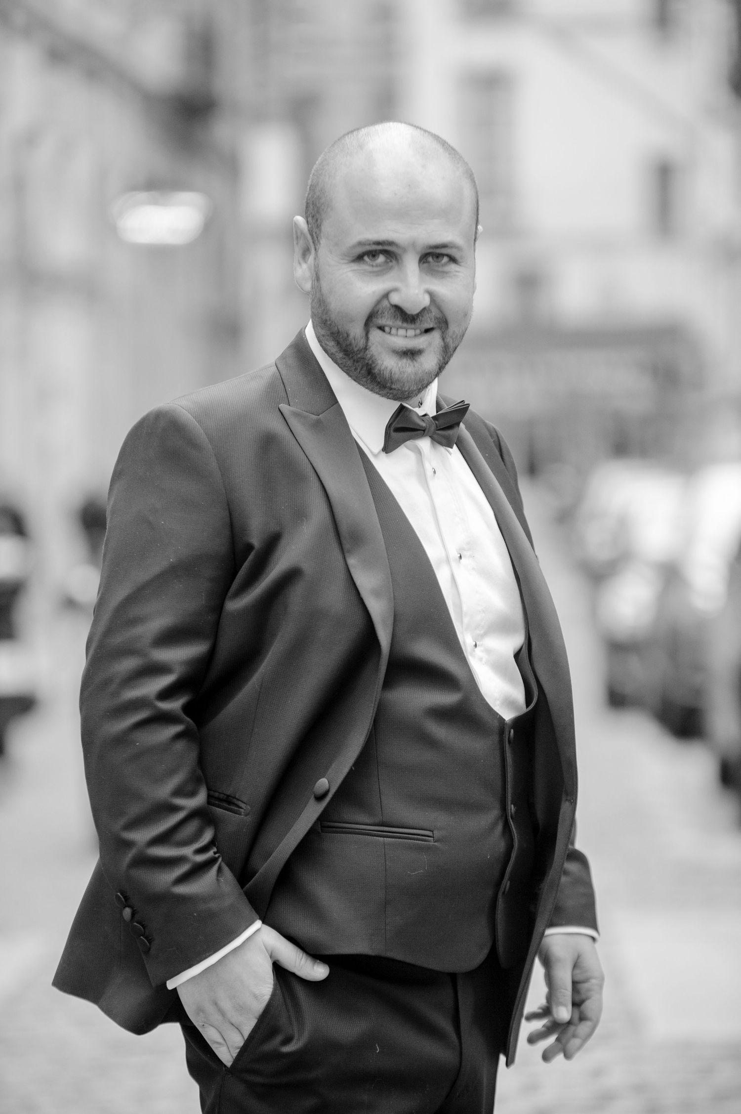 A groom in a classic black tuxedo and bowtie poses confidently in a multi-panel portrait series.