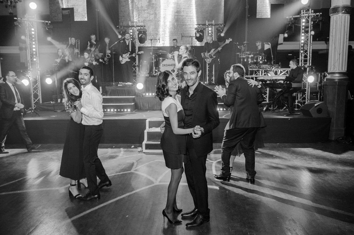 Black and white photos show couples dancing together in an evening street scene with city lights in the background.