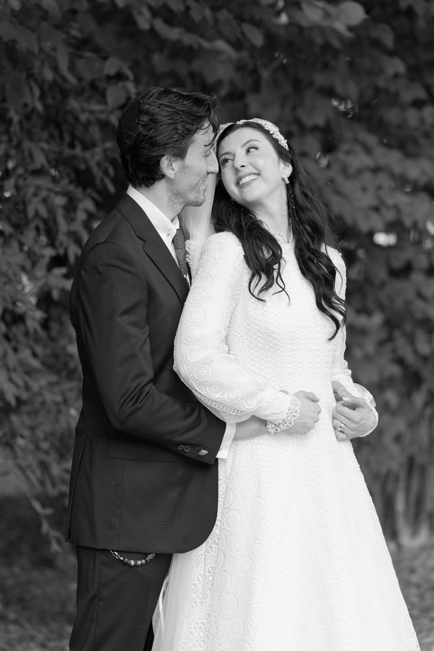 A romantic wedding couple shares intimate moments in a series of black and white photographs outdoors.