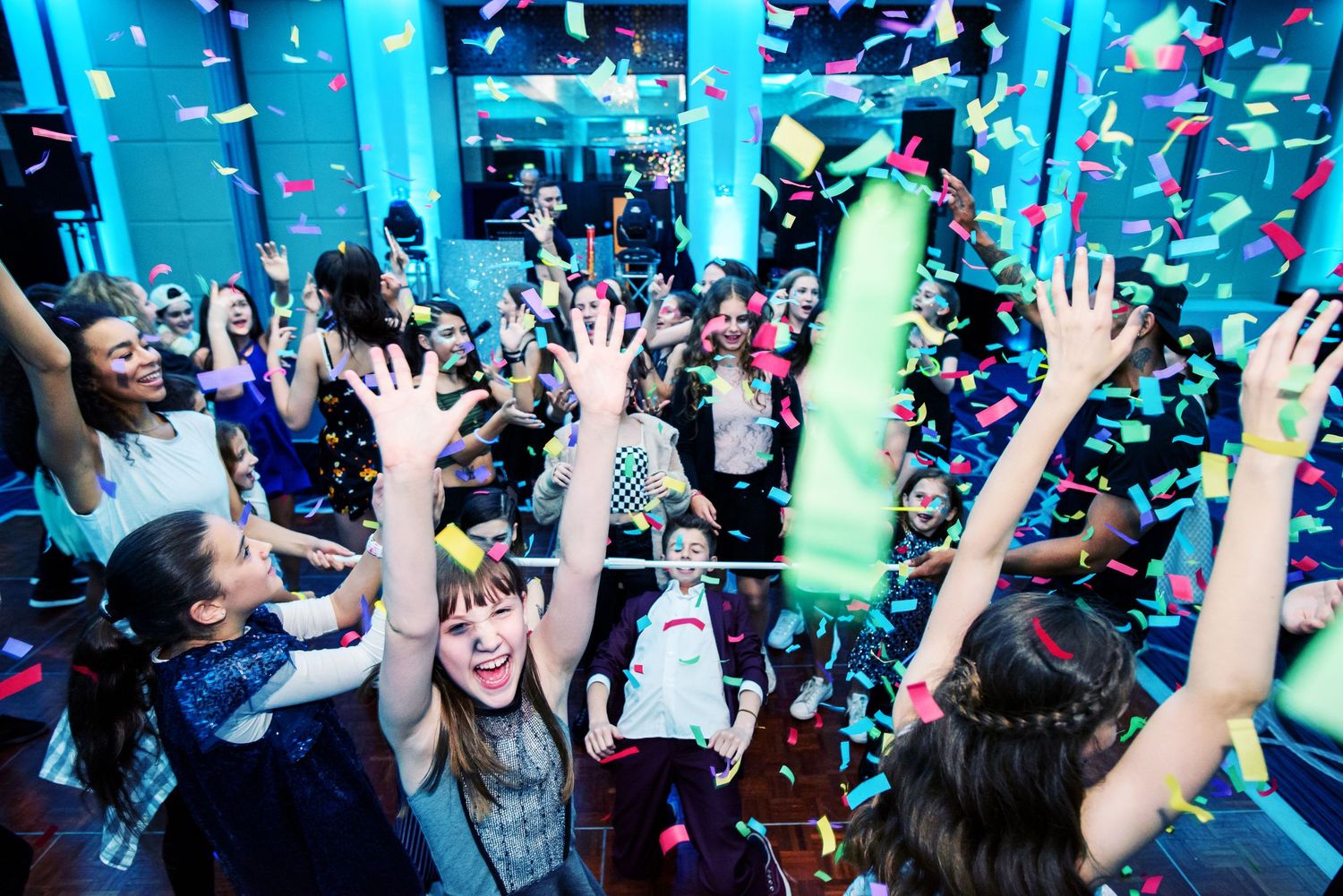 Nightclub celebration with blue lighting and confetti falling as crowd dances.