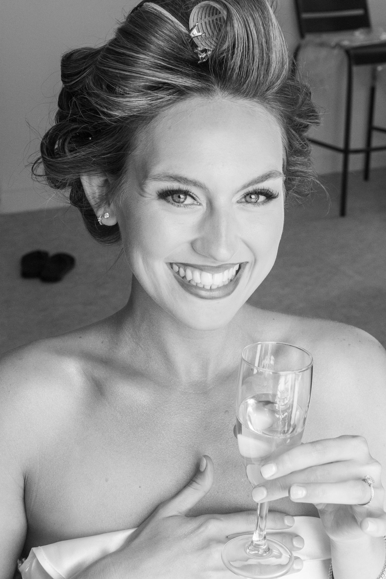 A series of black and white photos showing someone joyfully holding a champagne glass in different poses.