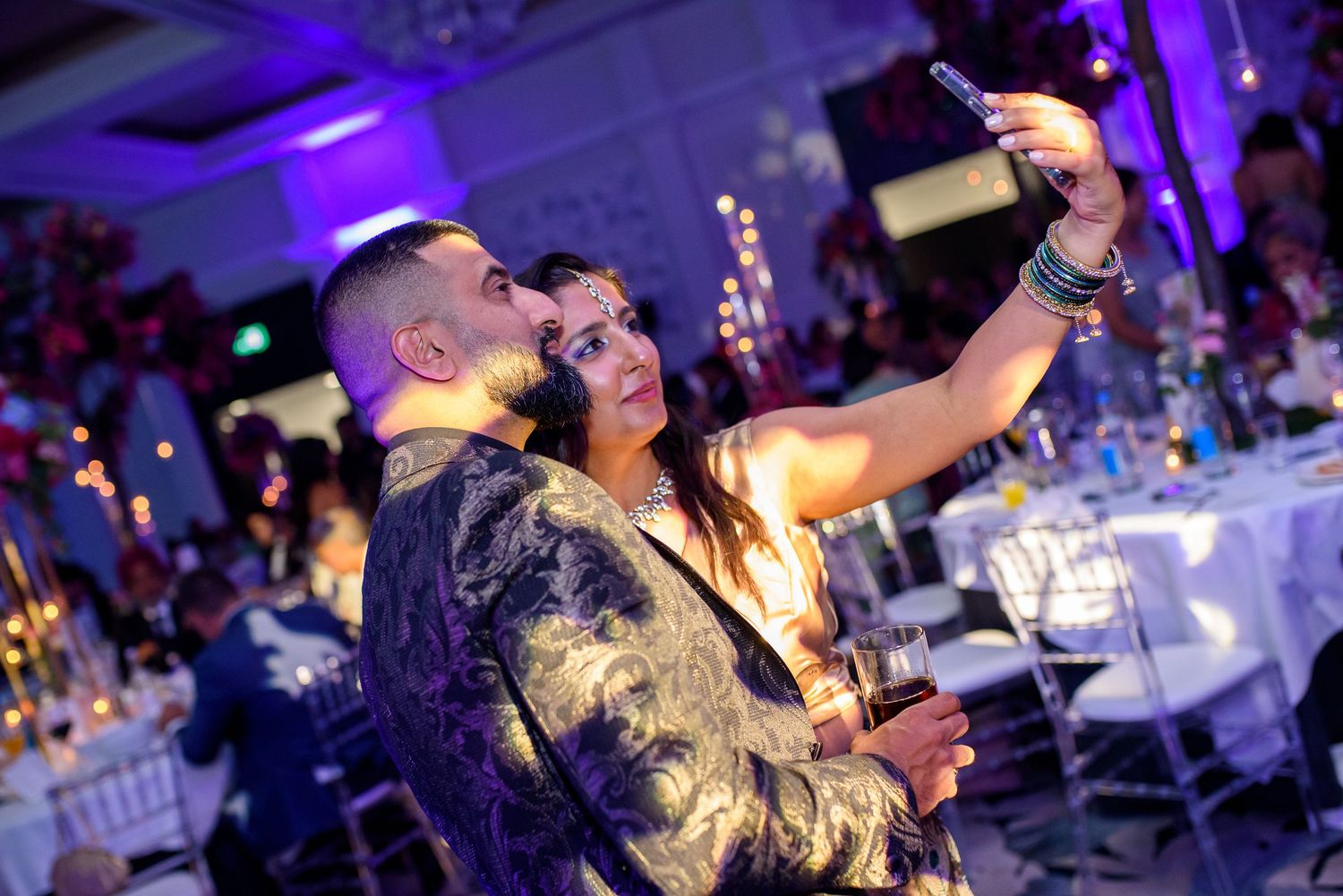 Performers singing on stage with dramatic purple lighting effects at a live concert event.