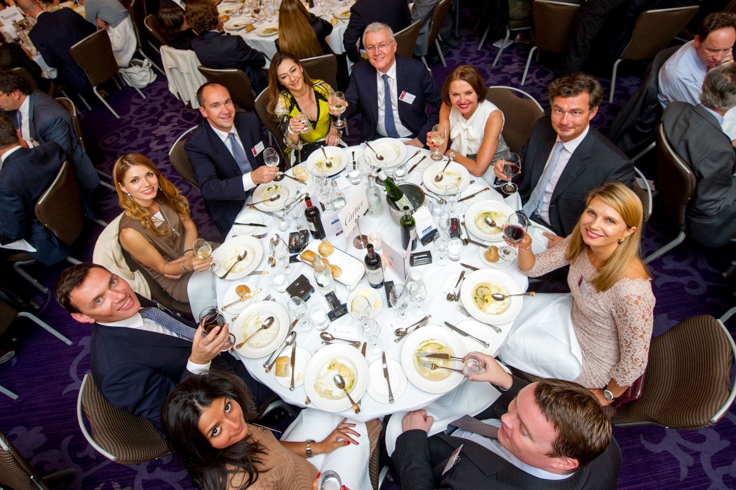 Formal dinner event with round tables and elegant place settings.