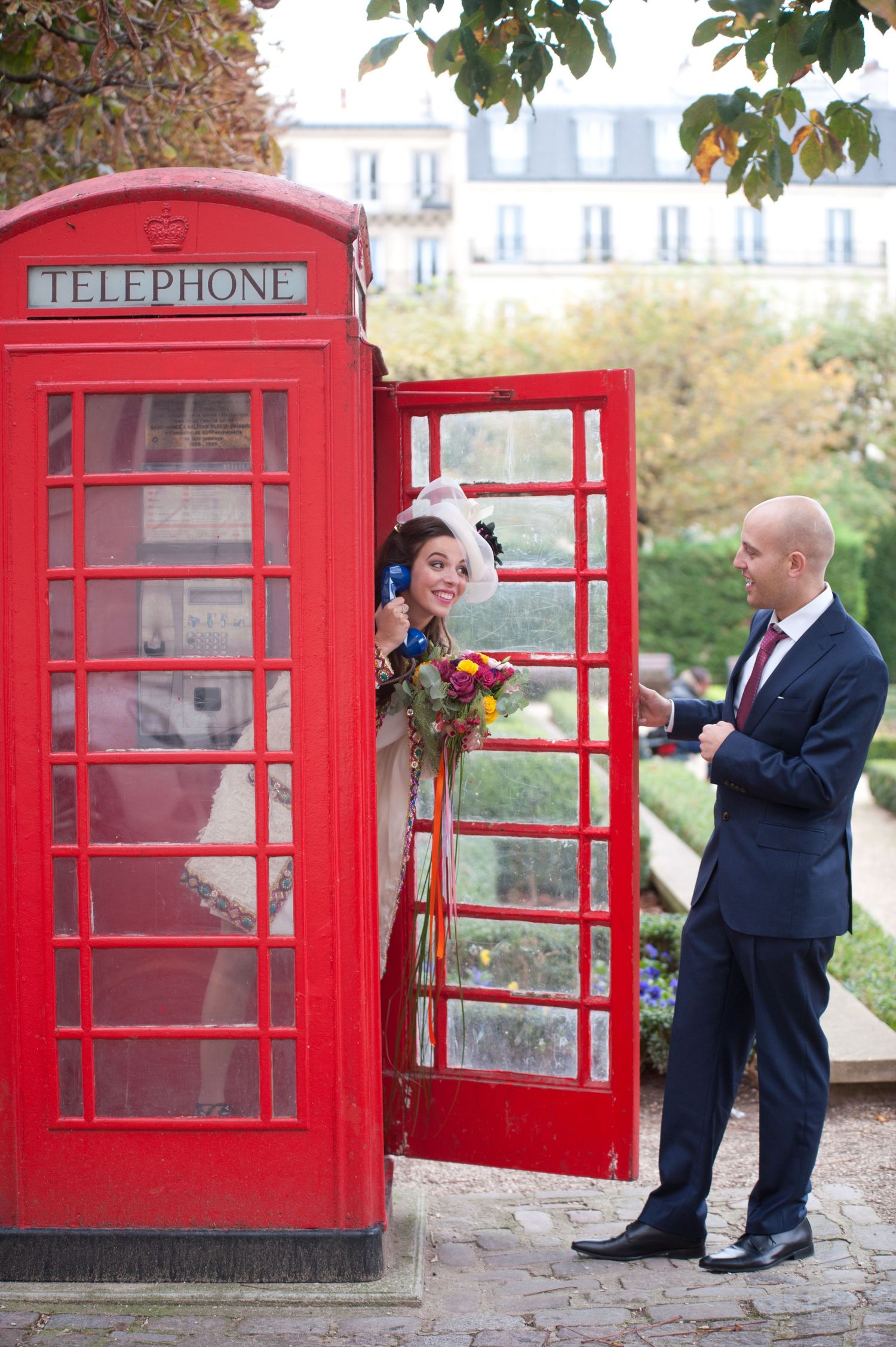 Romantic wedding photo sequence with couple posing playfully by iconic red British telephone boxes.