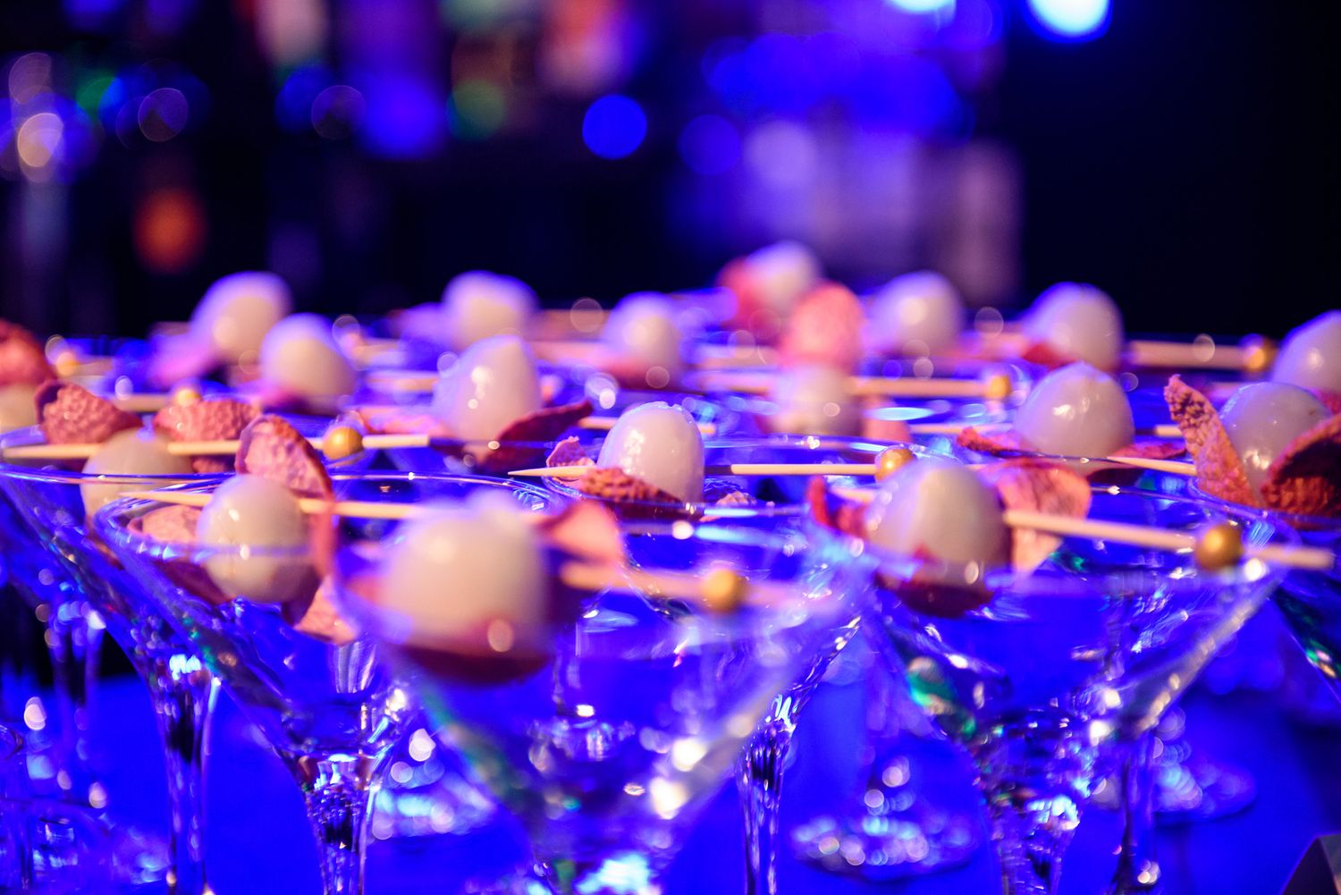 Elegant banquet hall illuminated with dramatic purple and blue lighting creating a luxurious atmosphere.