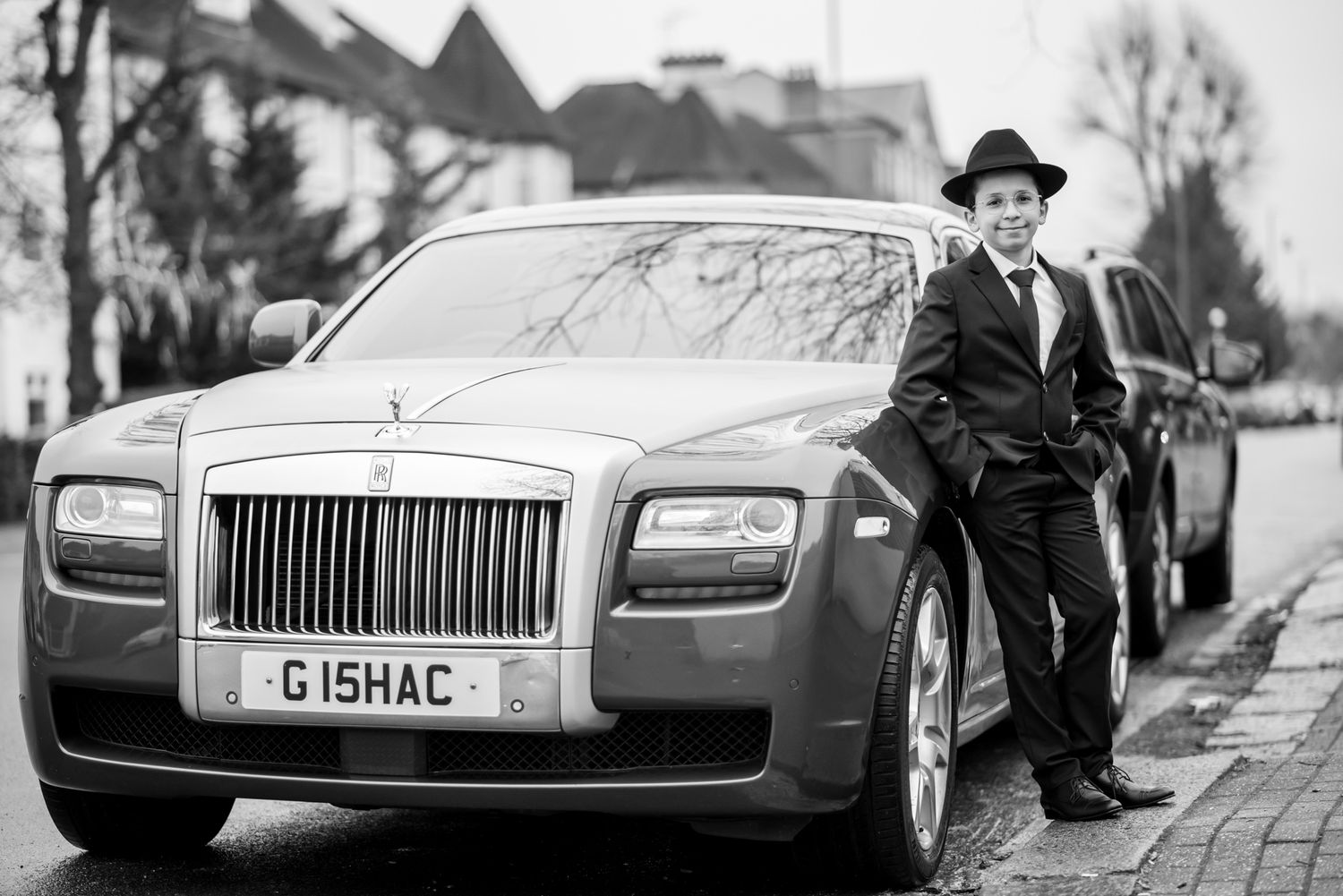 A black and white panoramic collage of luxury Rolls-Royce vehicles and vintage car scenes.