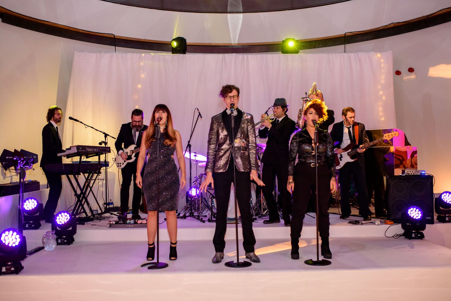Event space with dramatic lighting and guests enjoying a performance.
