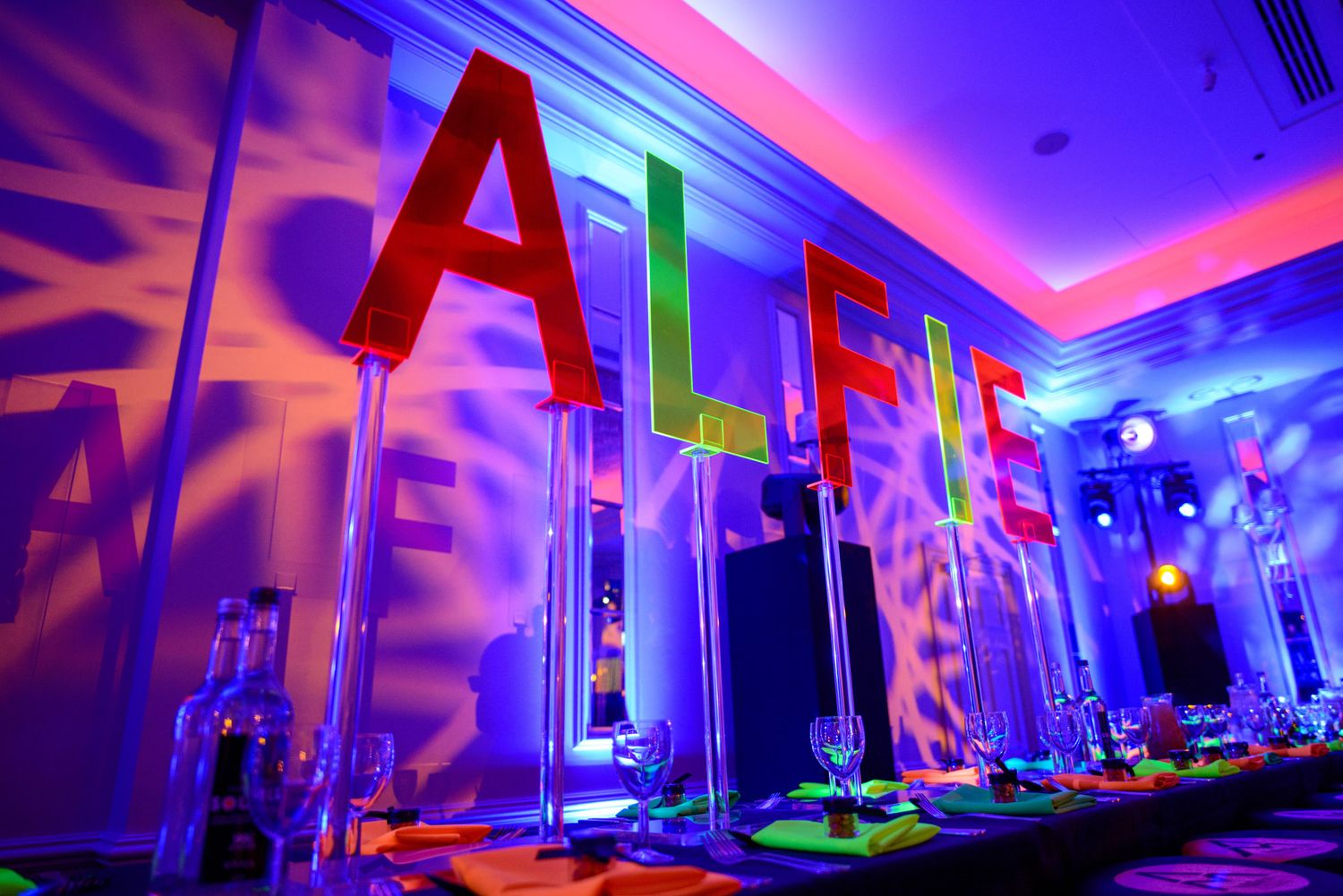 Colorful LED lighting illuminates a modern event space with pink and blue hues creating a vibrant party atmosphere.